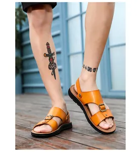 Close-up van stijlvolle oranje leren herensandalen met verstelbare gespen.