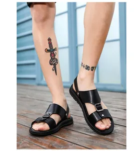 Gedetailleerd overzicht van trendy zwarte herensandalen met gesp op een houten dek.