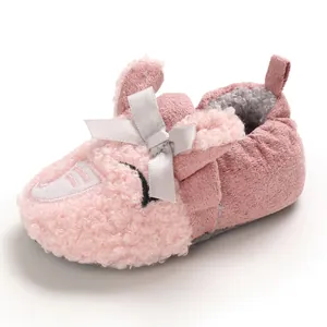 Primer plano de zapatos calientes rosa para bebé con un lindo lazo de dibujos