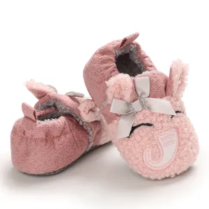 Primer plano de zapatos de bebé elefante rosa con suela blanda y detalle de lazo gris