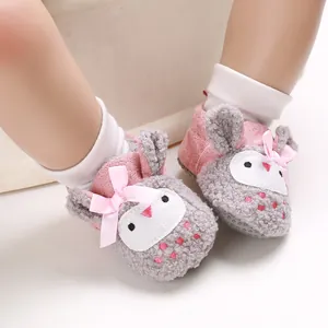 Detalle de zapatos de invierno para bebé con diseño de conejo, forro polar y lazo rosa.