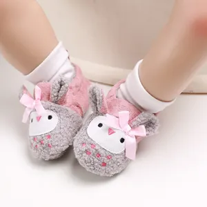 Primer plano de zapatos suaves de felpa para bebé con diseño de búho y lazos rosa