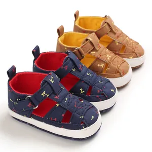 Detail of navy and brown baby walker sandals with airplane prints and soft white soles.