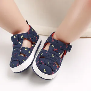 Detailed view of navy blue baby sandals with palm tree patterns and soft white soles