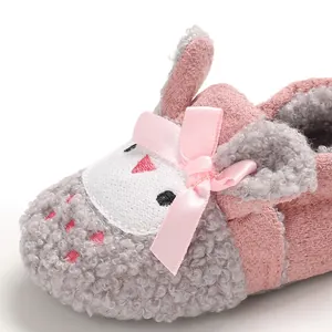 Primer plano de zapato de bebé peludo con un lazo rosa y diseño de animal animado.