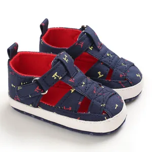 Detail view of navy blue baby sandals with tropical print and soft white anti-slip soles.