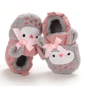 Detalle de zapatos para bebé en rosa y gris con suelas blandas para el invierno.