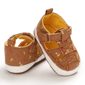 Detailed side view of brown canvas baby sandals featuring palm tree prints and soft soles.