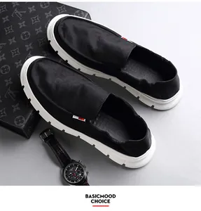 Detail of breathable men's black canvas slip-on loafers with durable white soles.