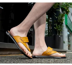Side view of comfortable mustard yellow flat thong flip-flops being worn outdoors