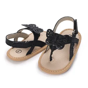 Detail view of baby girl sandals with black glitter straps and butterfly decoration