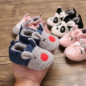 Primer plano detallado de zapatos de peluche para bebé con diseños de animales de dibujos animados