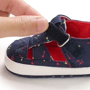 Close-up of navy baby sandal with adjustable velcro strap and red interior lining.