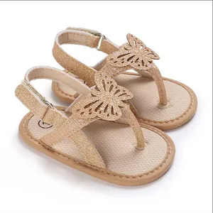 Close-up of gold glitter baby walking sandals with butterfly applique and soft soles