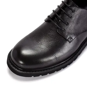 Detailopname van de zwarte echt lederen textuur op Britse stijl heren derby schoenen