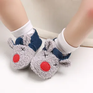 Primer plano de adorables patucos de bebé con diseño de reno y forro polar