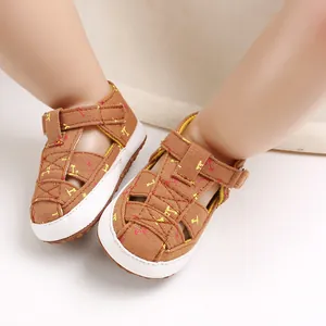 Close-up of brown cotton baby sandals with soft soles and cute yellow and red motifs