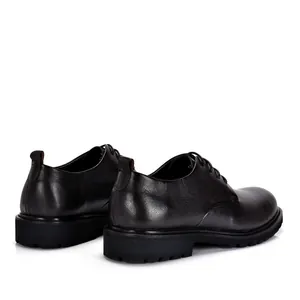 Detailweergave van zwarte vintage leren herenschoenen met een dikke rubberen zool