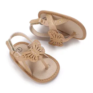 Close-up of gold shimmering baby sandals with butterfly decor and breathable soft sole
