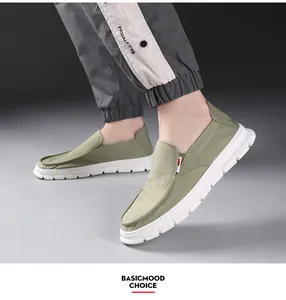 Side detail showing olive green men's canvas loafers with white lightweight soles