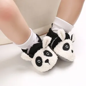 Primer plano de zapatos de peluche para bebé con diseño de panda y suela blanda