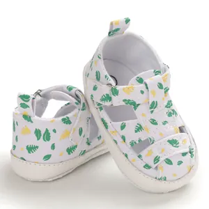 Detail van witte babysandalen met bladprint en zachte zool voor de zomerse wandeling