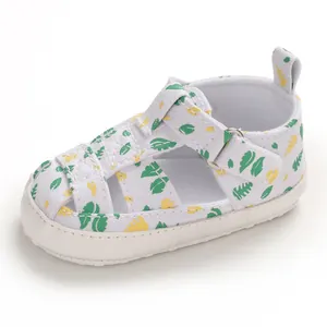 Detailweergave van witte baby canvas wandelsandalen met groen bladpatroon en bandjes