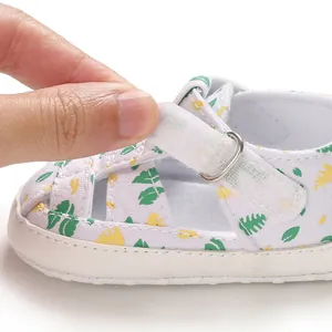 Detail van witte baby wandelsandaal met bladprint en verstelbare klittenbandsluiting