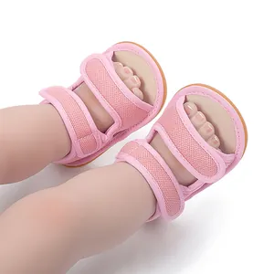 Detailed view of pink mesh baby sandals with non-slip rubber soles on infant feet