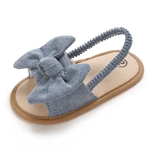 Vista detallada de sandalias de aprendizaje para bebé en denim azul con un gran lazo