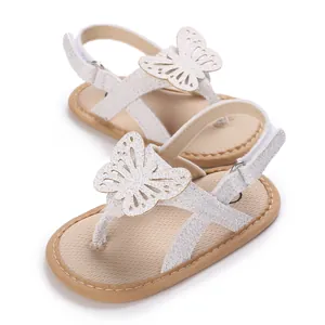 Detailed macro view of white baby sandals featuring sparkly butterfly ornaments and hollow design