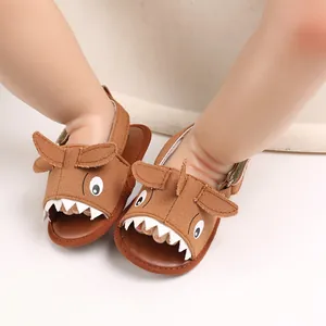 Close-up of brown cartoon shark baby sandals with soft soles and canvas texture