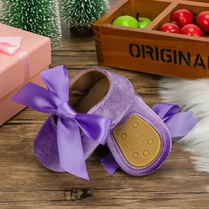 Detailed view of purple velvet infant princess shoes featuring a large satin ribbon bow