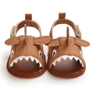 Detailed view of brown cartoon shark-themed baby sandals with soft soles