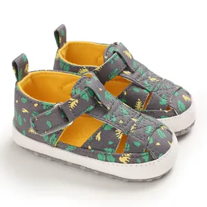 Gedetailleerde weergave van grijze baby loopsandalen met levendige groene bladpatronen