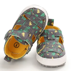 Detailweergave van zachte baby sandalen met tropische bladerprint en gesloten teenontwerp.
