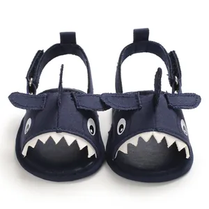Detailed front view of navy blue cartoon shark baby sandals with white teeth