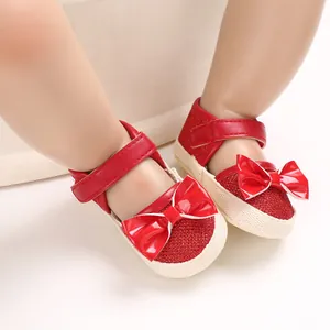 Close-up of red baby princess pre-walker shoes with shiny bow and soft comfortable sole