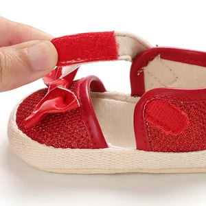 Close-up of a red glitter baby walking shoe showing the hook-and-loop fastener detail