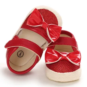 Close-up of red glitter baby princess shoes with patent leather bows and soft soles