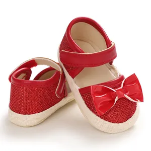 Detail view of red sparkly baby princess shoes with a bow and soft textured sole