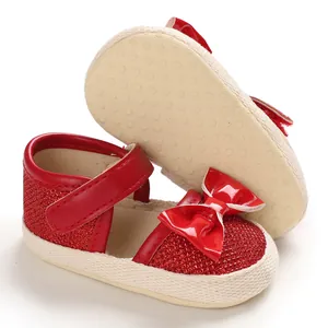Detail view of red glitter baby princess shoes with a bow and anti-slip sole