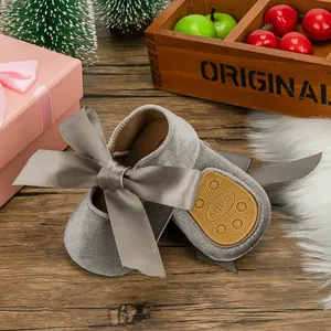Close-up of velvet baby princess shoes with ribbon bow and non-slip soft sole