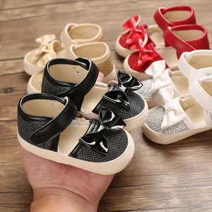 Close-up of baby girl walking shoes with bow detail and glitter texture