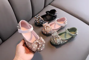 Close-up of girl's flats with rhinestones, pearls, and a large bow detail.