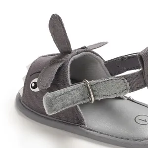 Close-up of shark baby sandal with adjustable velcro strap and canvas texture.