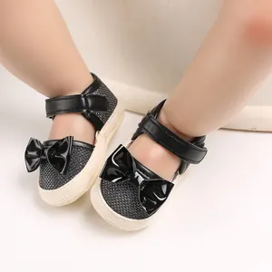 Detail view of black baby princess shoes with shiny bow decoration and soft sole