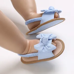 Primer plano de sandalias azul claro para bebé con lazo decorativo y suela blanda