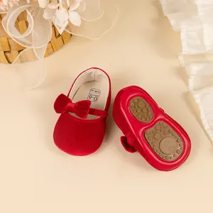 Detail showing the soft sole and velvet bow of these red baby princess shoes.