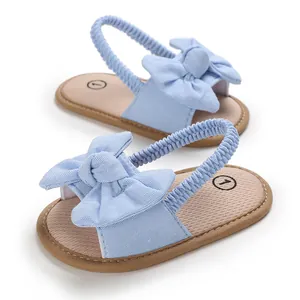 Detalle de sandalias para bebé azul claro con lazo decorativo y suela blanda y cómoda